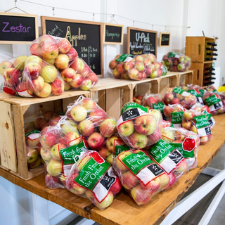 Table full of bagged apples in The Glass Orchard store