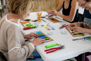 A group of students working on glass fusing projects together