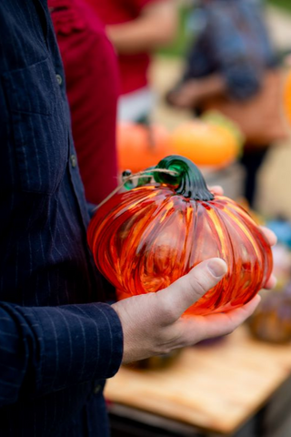 Single glass pumpkin held by customer