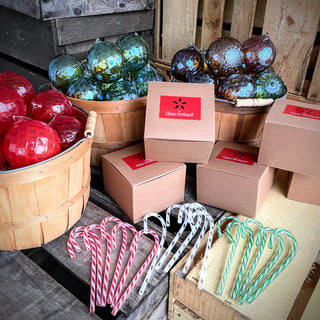 Display of glass candy canes and glass ornaments in baskets