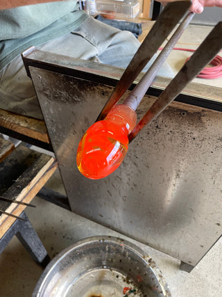 Molten glass being squeezed by a tool