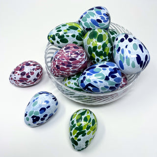 Handblown glass eggs in various colors sitting in a bowl