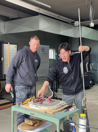 Instructor and student finishing up a class project in the hot glass studio