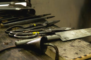 Various glass blowing tools sitting on a bench