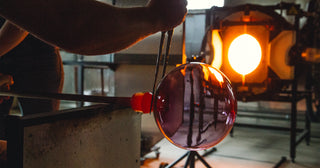 Glass vessel being created in the hot glass studio by two artists