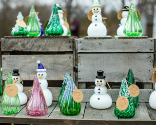 Display of glass snowpeople and glass trees outdoors